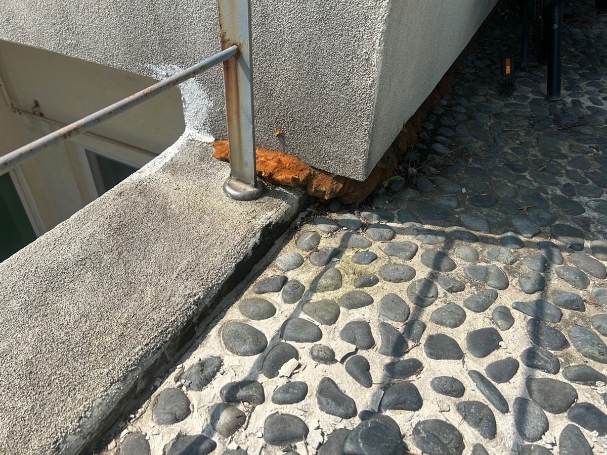 난간 기둥 아래, 벽과 바닥이 만나는 모서리에도 녹과 틈이 보였습니다